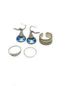 Three silver rings together with a pair of silver and enamel earrings