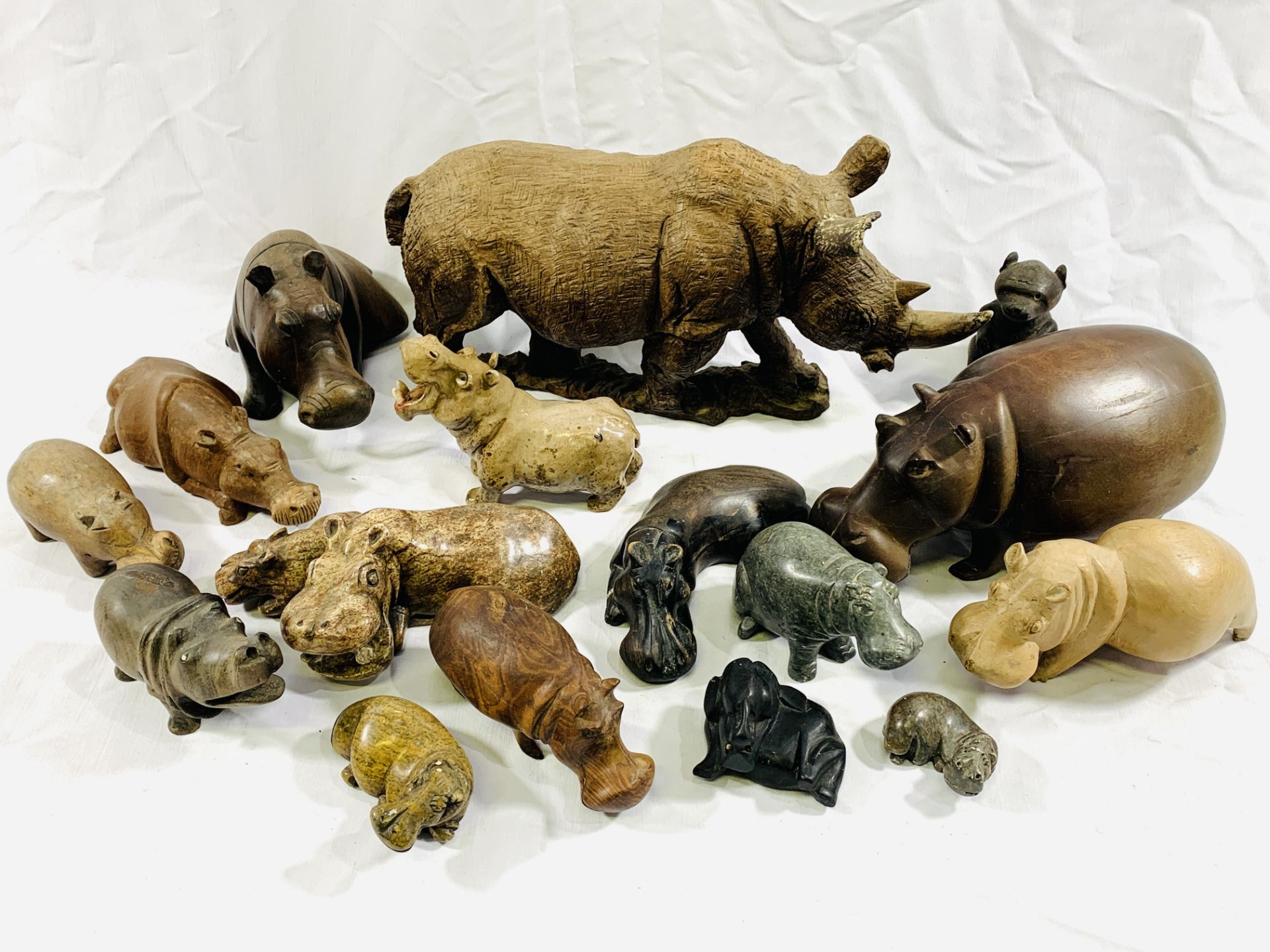 A quantity of carved wood and stone hippos