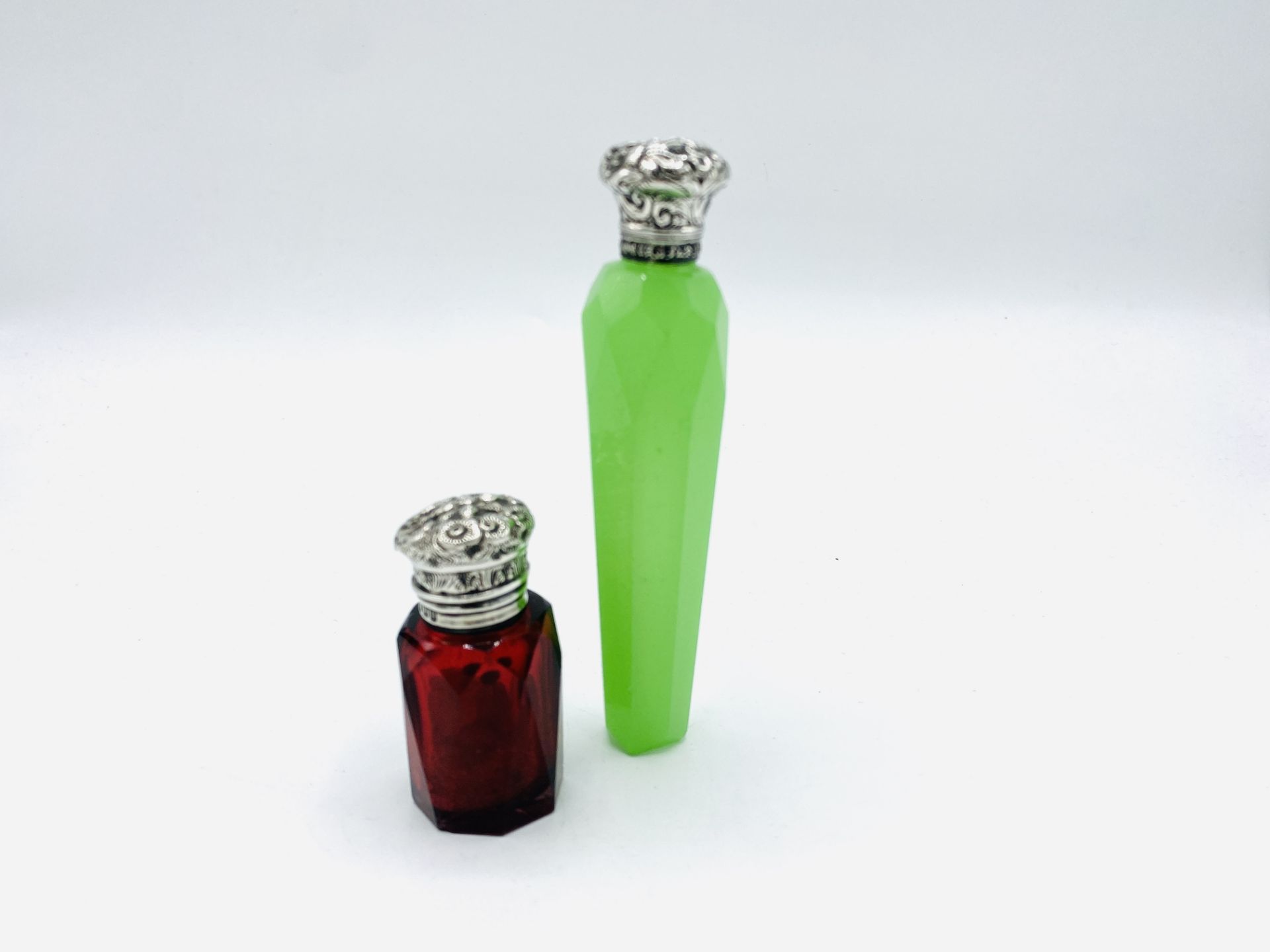 Faceted lime green glass scent flask and a faceted red glass scent bottle