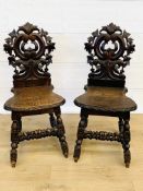 Pair of oak hall chairs with carved thistle backs