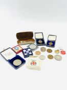 A collection of lapel badges and coins