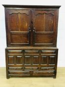 Two door oak cupboard over panelled base with five drawers