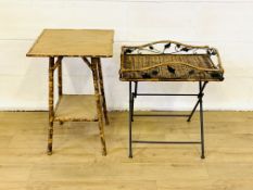 A bamboo side table and a folding metal table with wicker top