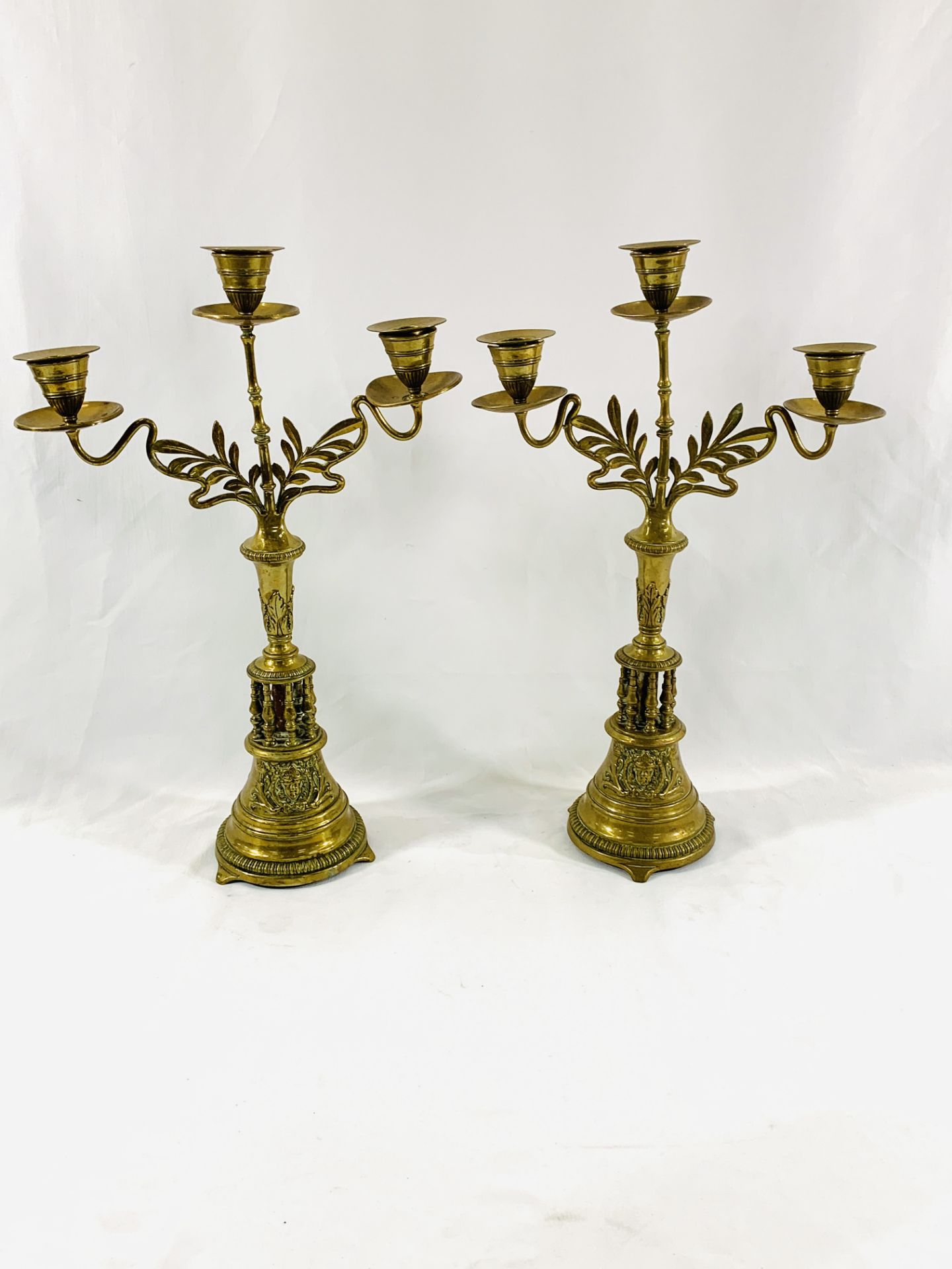 A pair of brass three branch candelabra