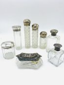 A collection of glass bottles and jars with silver tops.