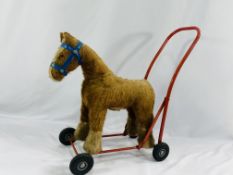 Push along toy horse together with a quantity of soft toys