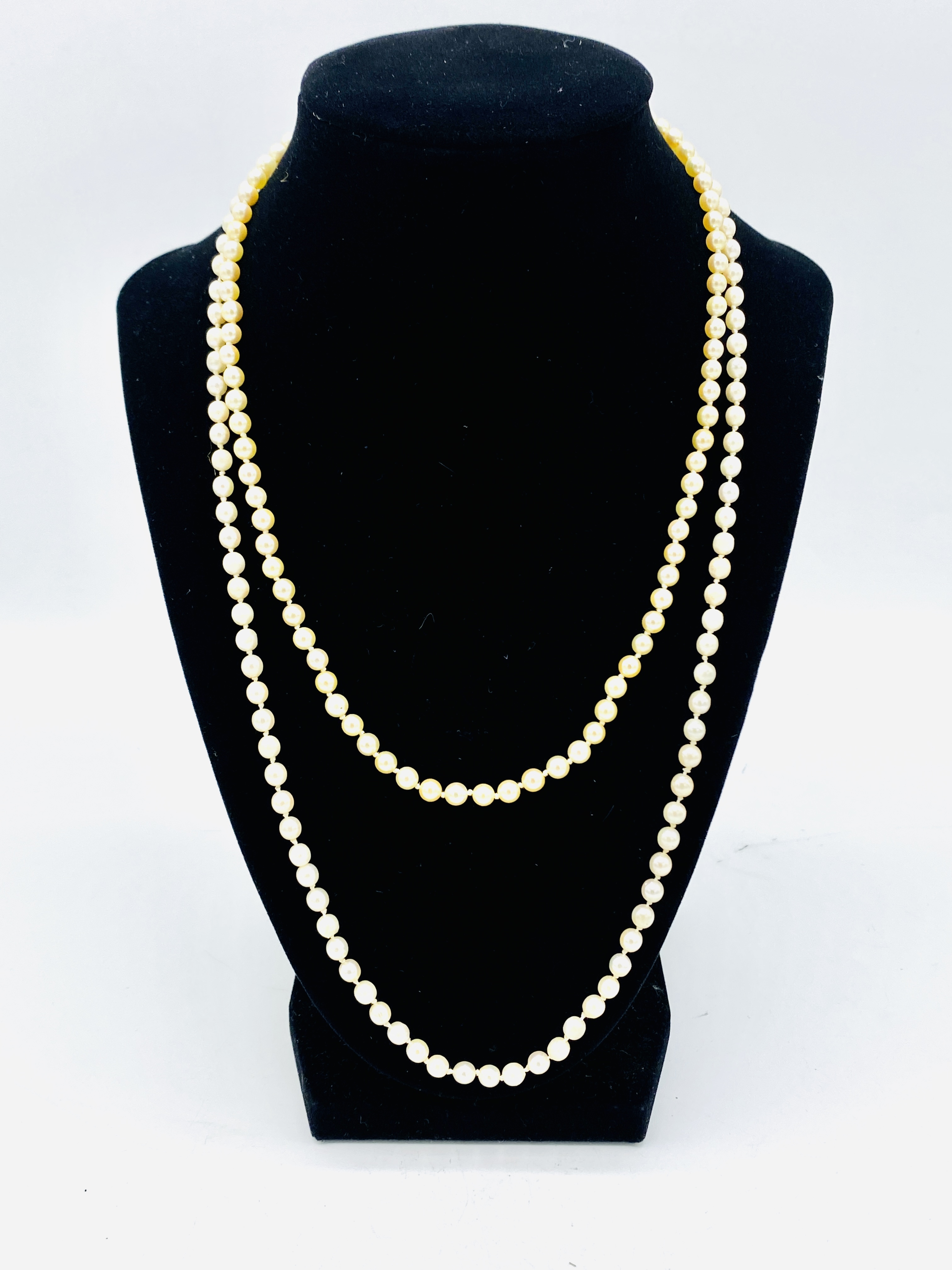 Two strings of pearls with gold clasps