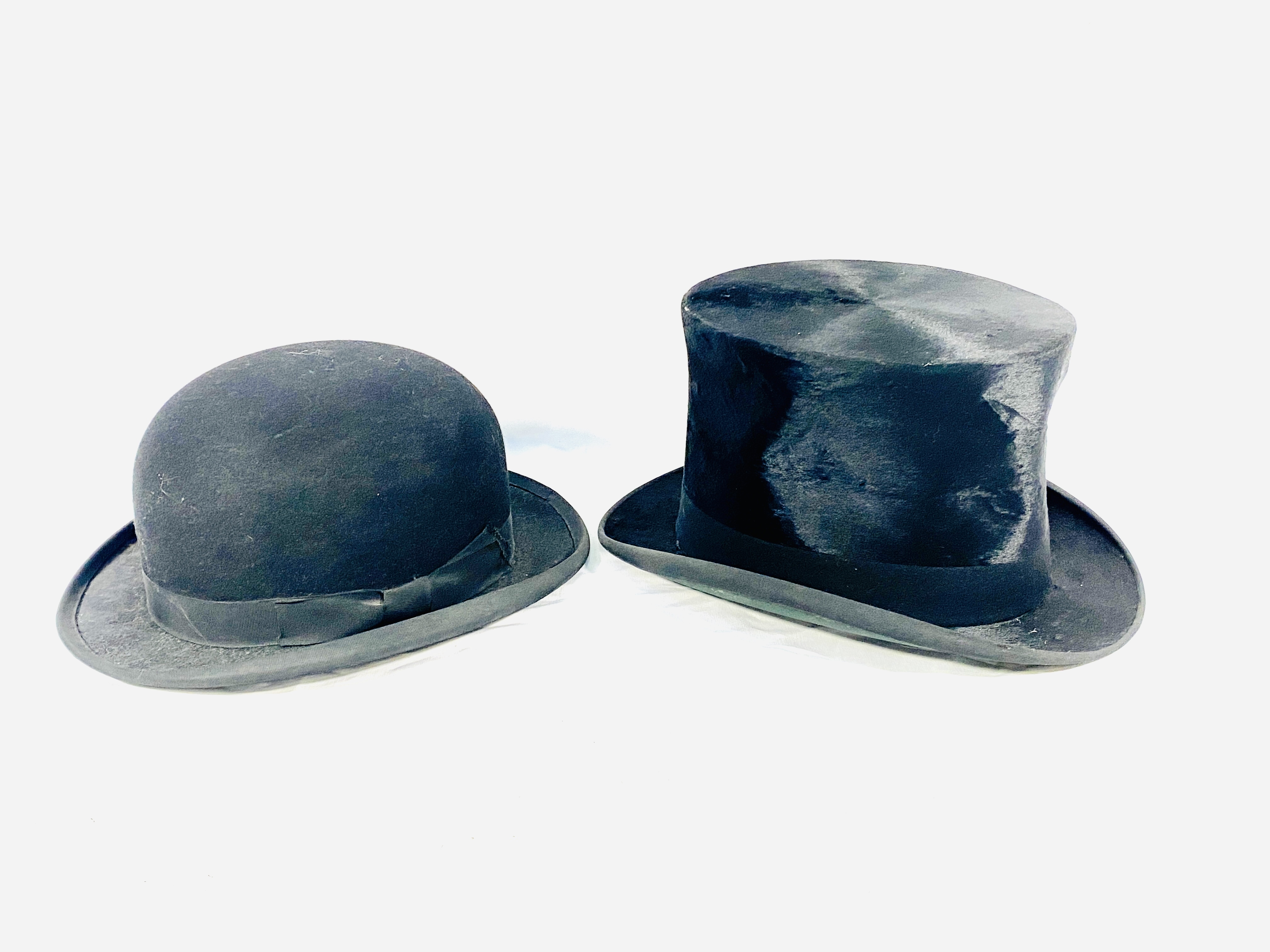 A silk top hat together with a bowler hat