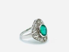 White gold ring set with an emerald and diamonds