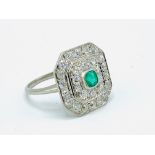White gold ring set with an emerald and diamonds