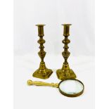 Pair of brass candlesticks and a brass magnifying glass