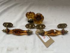 A pair of amber coloured brass mounted door handles together with a pair of matching door knobs