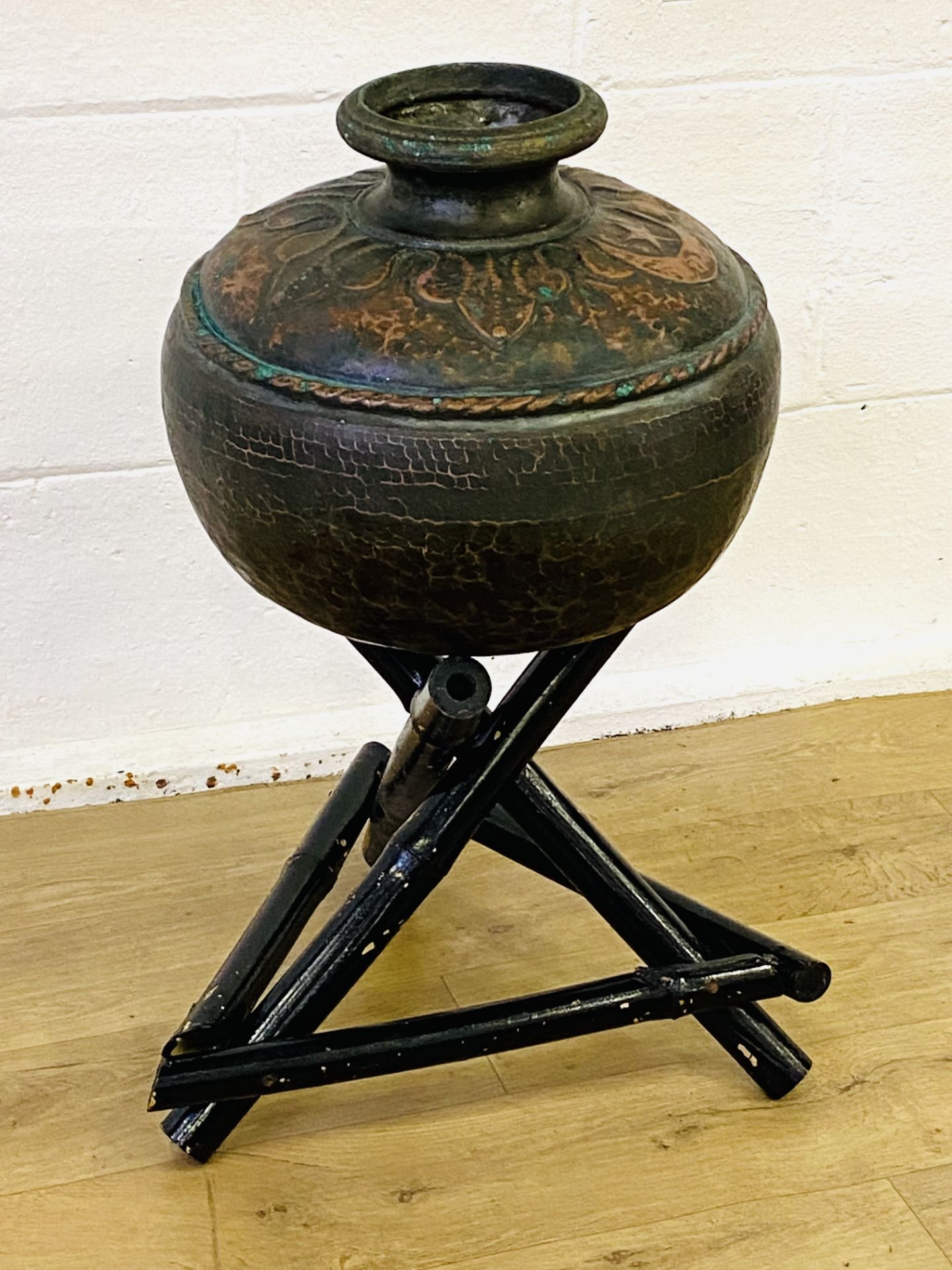 Hammered copper pot on wood stand