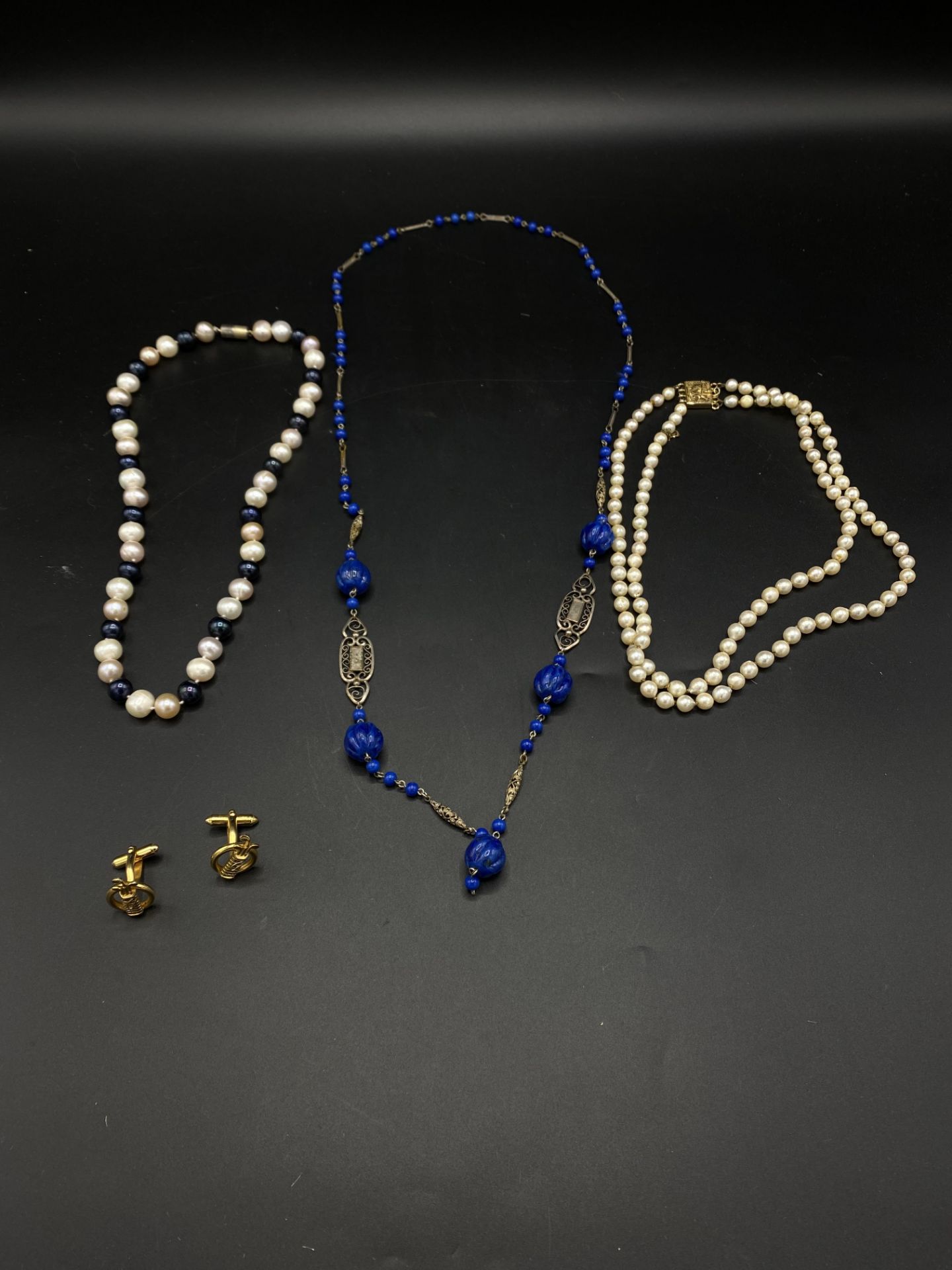 Two pearl necklaces, a white metal necklace and a pair of cufflinks