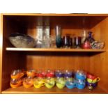 Two shelves of glassware to include a large collection of colourful plastic cups
