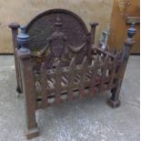 Antique cast iron fire grate of small proportions, the backplate with flaming urn and swags, with