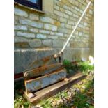 Large iron floor standing hand operated guillotine, fixed upon a wooden plinth