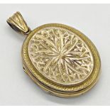 Yellow unmarked metal locket with engraved decoration. Measuring 3.5 cm x 2.5 cm approx. Weight 13.