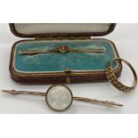 A 9ct gold bar brooch with a central cabochon banded agate in fitted box 5 cm long approx together