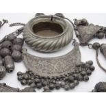 Large collection of Eastern white metal tribal jewellery pieces and artefacts to include pedants,