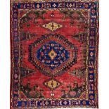 Turkish full pile rug, central blue medallion, washed red ground, 210 x 165cm