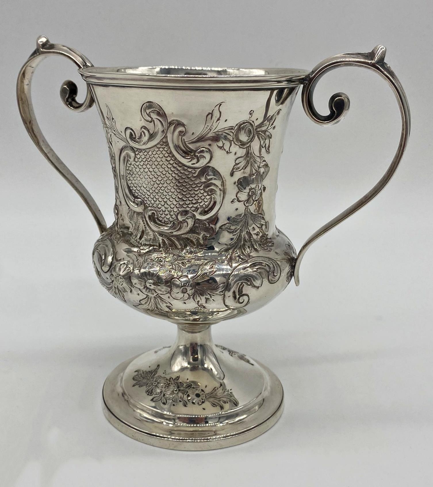 Georgian white metal twin handled cup, with later Victorian chasing, no hallmarks present, 17cm