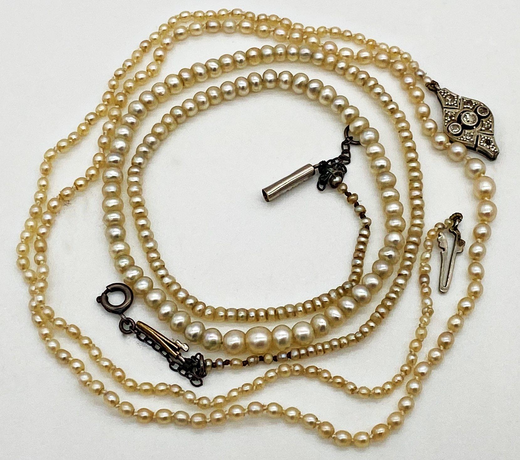 An antique string of graduated seed peals with a Diamond set clasp stamped to the reverse 18ct Plat.