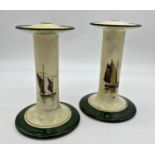 A pair of Royal Doulton ceramic candle sticks, each decorated a boating scene, 23cm high