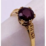 An 18ct gold ring set with a red Garnet solitaire stone. Size P, weight 2.6 grams approx.