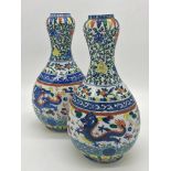 A pair of early 20th century Chinese porcelain gourd vases with hand painted decoration of dragons