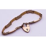 9ct gold gate bracelet with padlock clasp and associated safety chain. Measuring 19 cm long end to