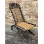 A North-Indian folding campaign type lounge chair with woven back and seat mounted by opposing