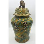 A large Chinese lidded ginger jar mounted by a dog of Fo with painted decoration of fruit amidst