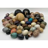 A large collection of marble and hard stone eggs together with three carpet bowls (a large