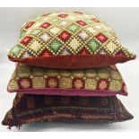 A good quality antique cushion with Persian rug upholstery with two further large woolwork