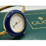 A ladies Gucci fashion watch with interchangeable bezel, the white dial with gilt hands, 25mm