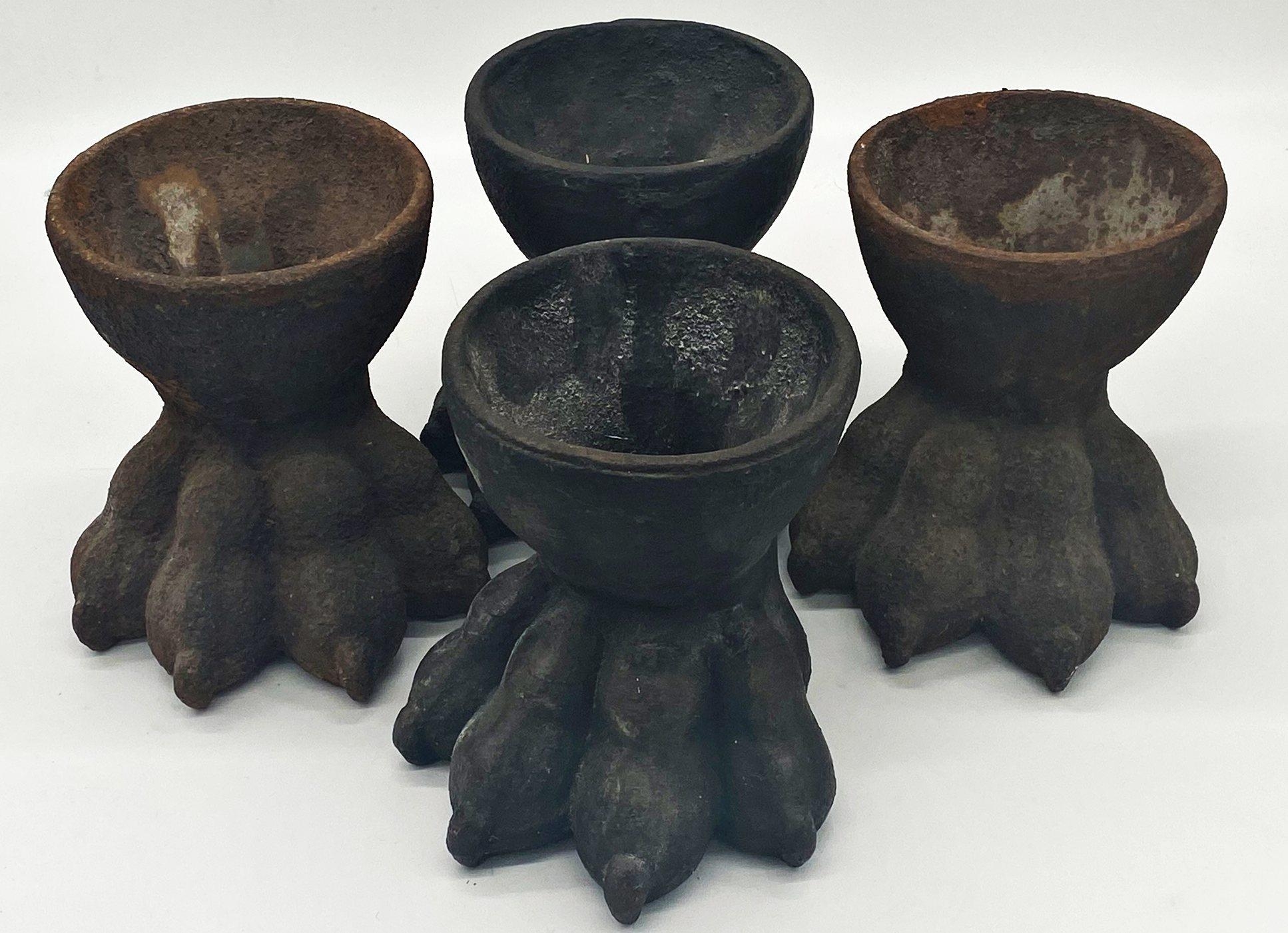 A set of four cast iron paw feet, with central well, 18cm high (4)