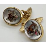 A pair of yellow metal cuff links set with painted and intaglio carved Essex crystals depicting a