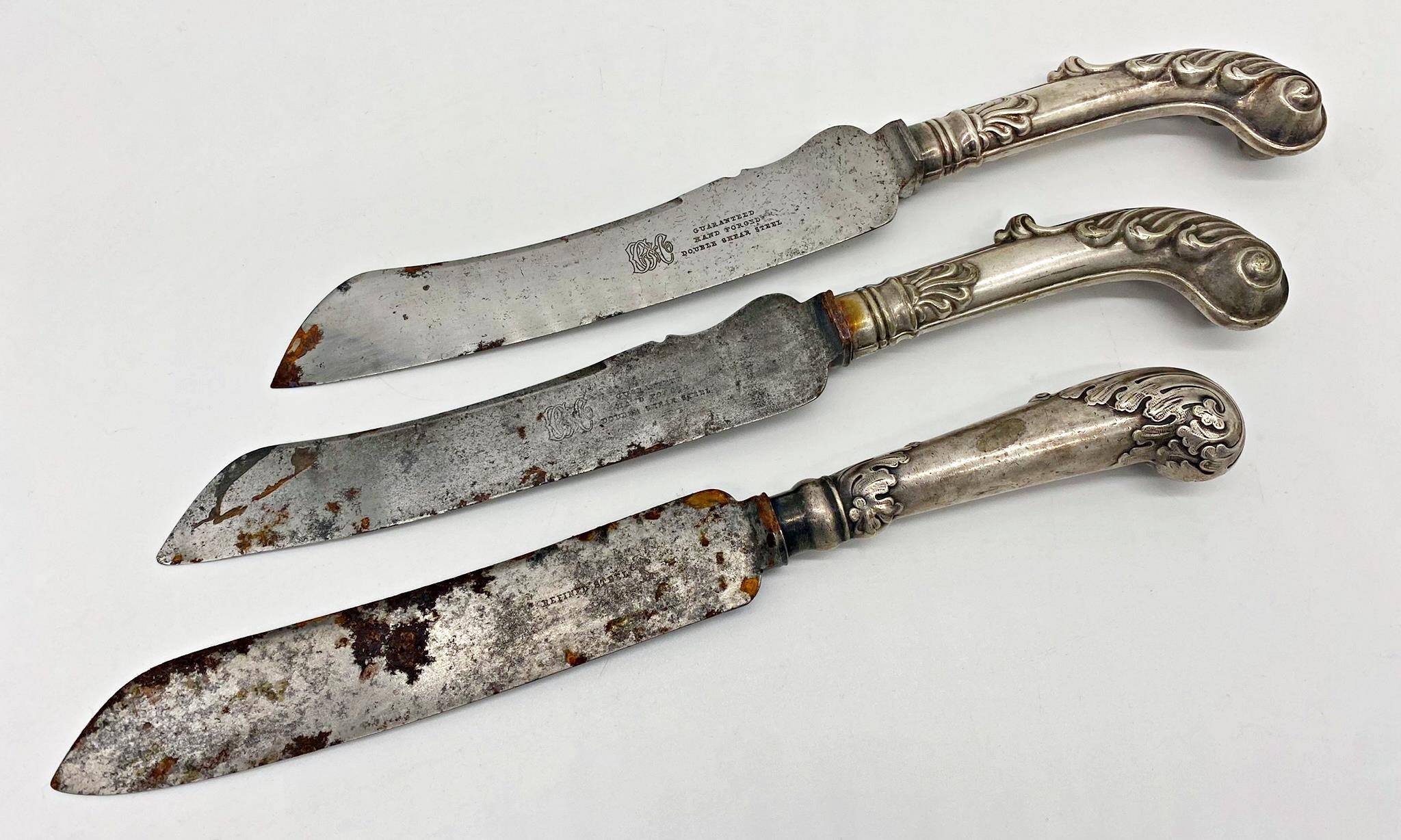 Pair of good quality white metal pistol grip handled carving knives, embossed with acanthus, 33cm