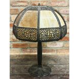A large four light Art Nouveau table lamp with large faceted glass shade with pierced metal mounts