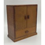 Art Deco fumed oak apprentice cabinet, twin doors enclosing a shelved interior over a single drawer,