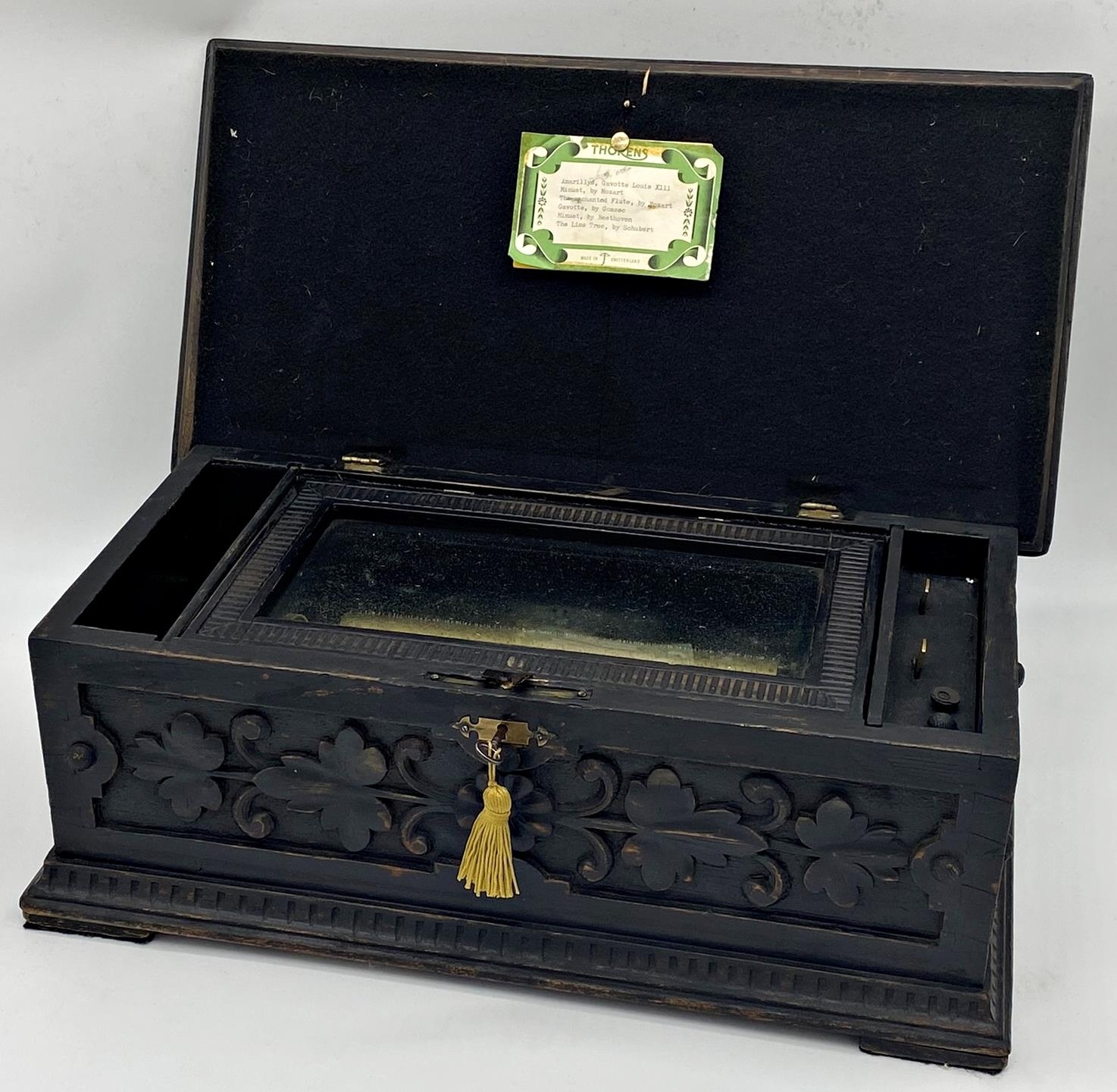 Late 19th century Swiss carved music box, the lid carved with lyre and scrolled foliage in a darted