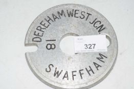 Metal single line tablet marked 'Dereham West JCN - Swaffham', 11cm diam