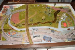 Miniature model railway housed in a wooden travelling case, the set modelled as a track running over