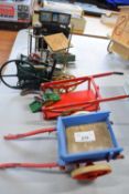 Mixed Lot comprising two small wooden carts, a small plastic traction engine, a small enigne part