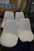 Four white dining chairs