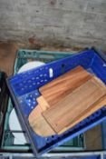 Two crates containing mixed serving plates and chopping boards