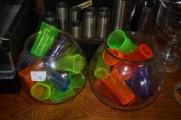 A large quantity of plastic shot glasses of varying sizes