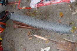 Rolled quantity of wire netting together with two fence stakes