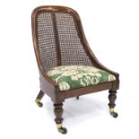 A Regency rosewood fireside bergere chair, circa 1820, curved back, drop-in upholstered seat,